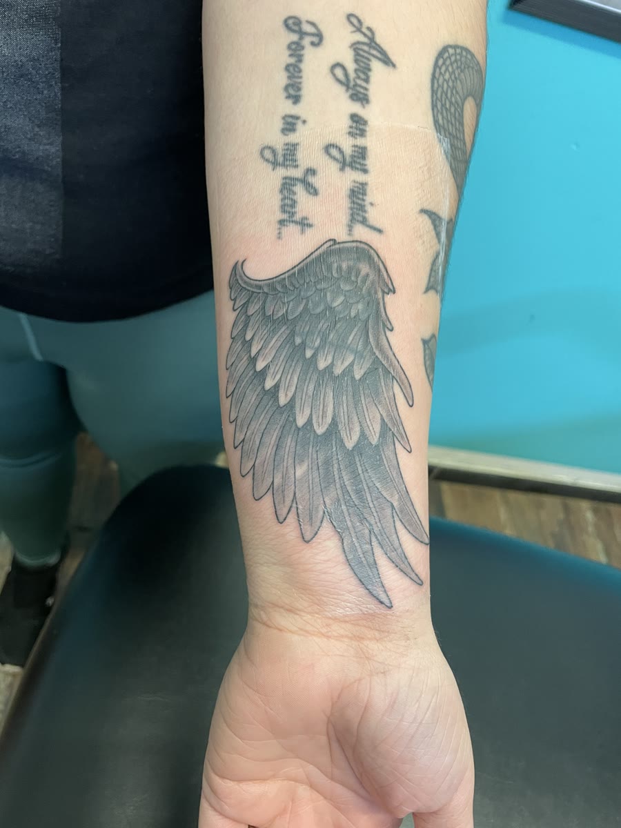 Frisch tätowiertes Flügel-Cover-up am Unterarm